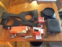 Photo of dashboard or interior door panels, boxed parts, and ignition components arranged on a wooden table.