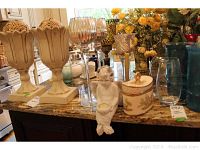 Full view of lot showing beige stained glass look candleholders, tall glass candleholders, angel mermaid figurine, ceramic candle container
