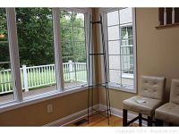 Full view of tall metal framed etagere positioned by windows, shows overall height and shape.