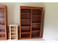 Front view of double-sided Whalen wooden bookcase with adjustable shelves showing overall condition and wood tone.