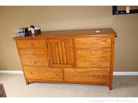 Front view of a wooden dresser showing a total of 8 drawers with 2 drawers hidden behind a central door.