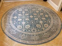 Round blue and beige Magnolia Home rug shown on tiled floor, full view.
