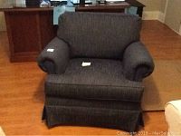 Front-facing photo of the blue upholstered Johnston Benchworks armchair with rolled arms and cushioned backrest.