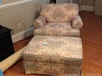 Floral-patterned Ethan Allen chair and matching ottoman set, light beige fabric with muted vintage floral design, shown in room with wood floor.