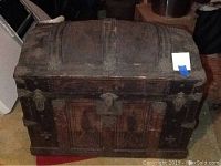 Full view of the antique wooden chest highlighting the dome-shaped lid and general size and shape.