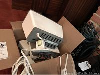 Group shot inside cardboard box showing Sonos Connect:Amp, Sonos Play:3 speaker, Ethernet hub, Lightning dock and cables