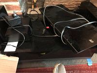 Wide view of turntable base, phono amp, Blu-Ray player and power cables on black glass table