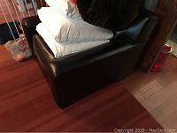 Right-front angle view of chair with cushions and pillows piled on seat