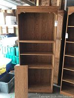 Front view of the oak look bookcase showing four adjustable shelves and one fixed shelf with oak wood grain finish.