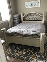 Assembled bed with mattress and linens showing headboard design