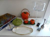 Wide shot showing the entire lot including juice glasses in Milwaukee crate, ceramic tomato jar set, serving dishes, small vase, foil cutter, bottle opener, and cupcake stand