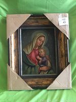 Full view of the framed religious oil painting showing Madonna and Child with protective corner cardboard on frame