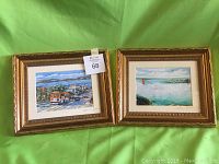 Two framed art prints depicting San Francisco scenes with gold-toned decorative frames on a green background.