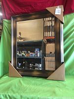 Full view of rectangular beveled mirror framed in a wide brown wood gallery frame with cardboard corner protectors.