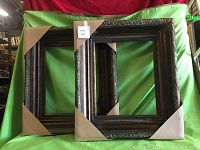 Pair of ornate dark wood gallery frames with corner protectors, showing size and shape.