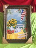 Full framed oil painting showing a bright and colorful outdoor scene including sunflowers, teapot, American flag and sailboats at sea.