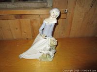 Full view of the porcelain lady figurine, showing the lavender dress and white dog at her feet.