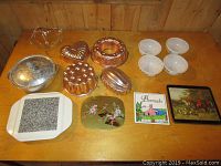 Full view of all jelly molds, bowls, trivets arranged on wooden table