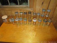 All 19 antique canning jars displayed on wood surface with visible variations in size and lid condition.