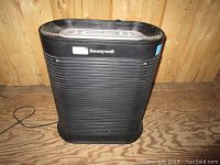 Front view of black Honeywell air filter unit showing grooved design and power cord.