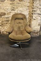 Front view of vintage light brown upholstered swivel lounge chair showing high backrest, cushioned seat, and padded armrests.