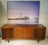 Front view of closed walnut veneer console showing fluted speaker grilles