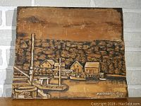 Frontal close up of carved relief showing houses, docks, boats, and hillside trees with "Northwest Cove N.S." inscription.