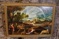 Full front view of painting and ornate gold frame leaning against stone wall