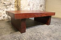 View from front-left side showing thick solid wood construction and natural wood grain of American Redwood table.