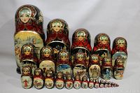 Five largest outer dolls lined up with nested mid-sizes behind and smallest dolls in front
