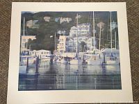 Full view of signed lithograph "Sausalito-Centennial" depicting Sausalito harbor and hillside buildings, with white border around image.