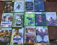 Top-down view of 13 games including Xbox 360, Xbox, and PlayStation 2 cases with visible titles and cover art.