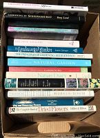 Photo of 14 gardening books stacked with spines visible showing titles related to gardening, flower preserving, bonsai, and natural garden care.