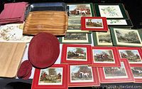 Overview of lot showing placemats with English hunting scenes, wooden tray and cutting boards, red woven mesh placemats and coasters, and floral placemats.