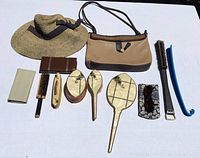 Top down view of the entire lot including the hat, purse, wallets, vanity mirrors and brushes, sunglasses, and shoe horn.