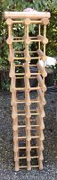 Full view of the tall wooden wine or bottle rack showing grid structure with places for 22 bottles.