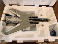 Top-down view of die-cast F-14 Tomcat model in white styrofoam packaging, showing overall aircraft shape and markings.