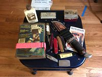 Full overview of knives, sharpening kits, honing oil, booklet and stones arranged on a table