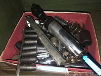 Box containing various chrome impact sockets, a pneumatic ratchet, and a socket rail.