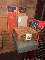 Breaker boxes stacked with boxes in background, one labeled GE 100 amps, showing condition and features.