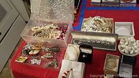 Close-up of assorted pearl-style necklaces and bracelets in cream, white, and pink shades inside the jewelry box.