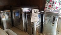 Photo showing the metal bread box and three metal canisters on a kitchen counter.