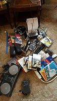 Wide view of radios, VHS tapes, DVD set, electronic components scattered on floor