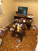 Wide view of the setup showing the wooden chair with toys on it, wooden computer desk with WOW computer on top, screen off, keyboard, and mouse visible.