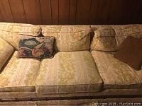 Top-down view showing yellow floral cushions and decorative pillows on couch.