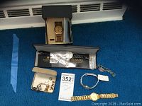 Overall lot view: multiple watches and cuff links on blue carpet