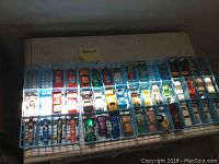 Overview of vintage toy cars organized in blue plastic display trays on a flat surface.