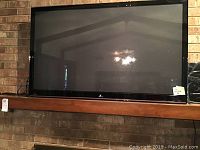 Front view of Zenith 52-inch TV displaying the 'Z' logo at bottom center of bezel on a brick background.
