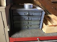 Front view of small metal tool chest with 4 drawers and wooden wine box beside it