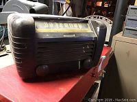 Front view of vintage RCA Victor tube radio showing front grill, tuning knobs, and frequency dial with glass covering and brand plate